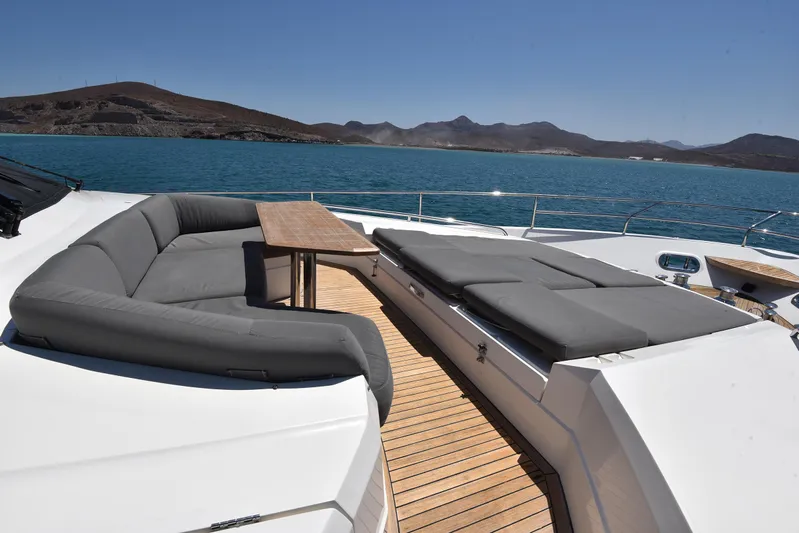 Princess One Yacht Photos Pics Luxurious 2014 Princess Flybridge 98Y yacht deck with seating and sunbeds, overlooking serene waters.