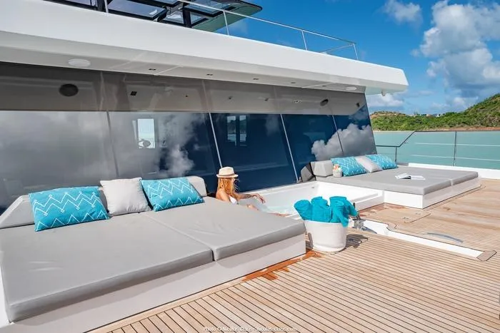 Rosa Del Mar Yacht Photos Pics Luxurious Sunreef Supreme 68 yacht deck with sun loungers, turquoise cushions, and ocean view.
