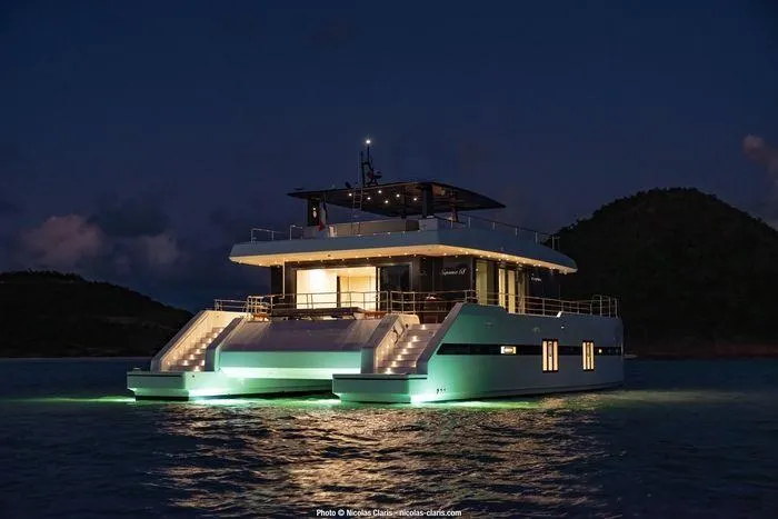 Rosa Del Mar Yacht Photos Pics Luxurious 2017 Sunreef Supreme 68 yacht illuminated at night on calm waters.