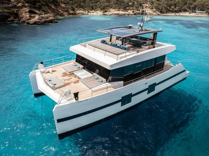 Rosa Del Mar Yacht Photos Pics Luxurious 2017 Sunreef Supreme 68 yacht on clear turquoise waters near a scenic coastline.