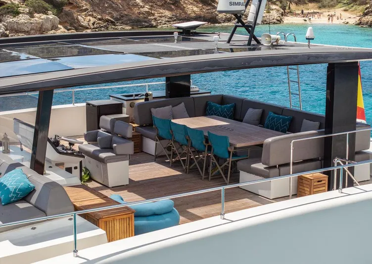 Rosa Del Mar Yacht Photos Pics Luxurious Sunreef Supreme 68 yacht deck with seating, 2017 model, near a scenic beach.