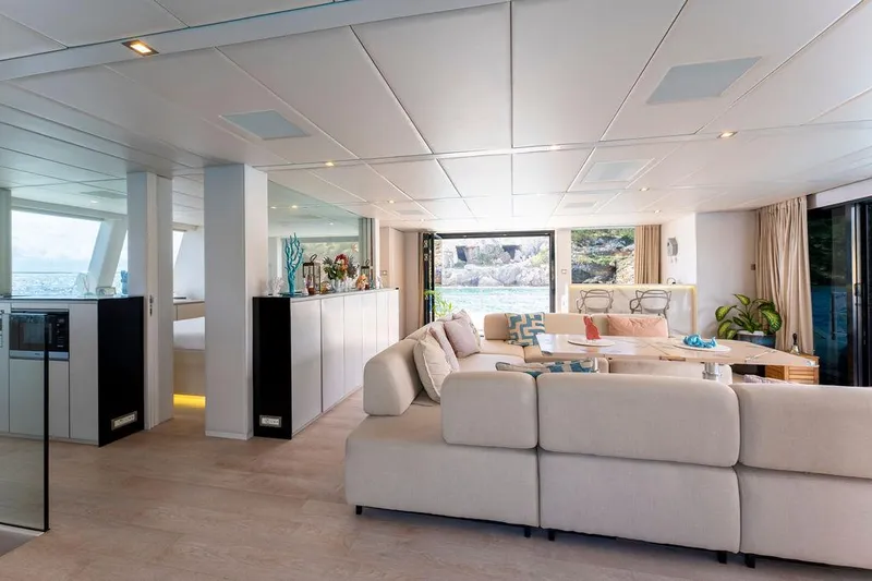 Rosa Del Mar Yacht Photos Pics Luxurious interior of 2017 Sunreef Supreme 68 yacht with modern furnishings and large windows.