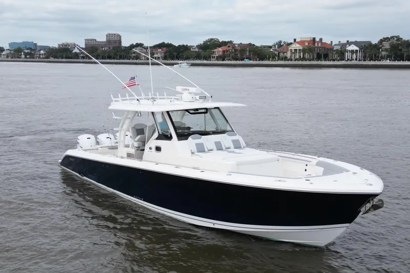  Yacht Photos Pics 2020 Pursuit S 408 Sport boat on calm water with cityscape background.