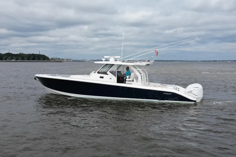  Yacht Photos Pics 2020 Pursuit S 408 Sport boat cruising on a calm, cloudy day.