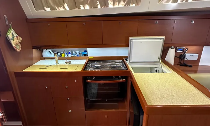 Lele Kalua Yacht Photos Pics 2014 Beneteau Oceanis 41 yacht kitchen with stove, sink, and storage cabinets.