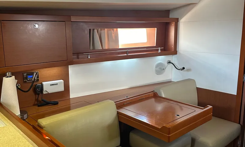 Lele Kalua Yacht Photos Pics Interior of 2014 Beneteau Oceanis 41 sailboat with wooden table and seating area.