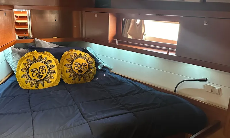 Lele Kalua Yacht Photos Pics Cozy cabin interior of 2014 Beneteau Oceanis 41 with sun-themed pillows.
