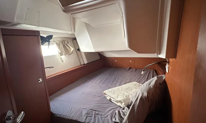 Lele Kalua Yacht Photos Pics Cozy cabin interior of 2014 Beneteau Oceanis 41 sailboat with bed and window.