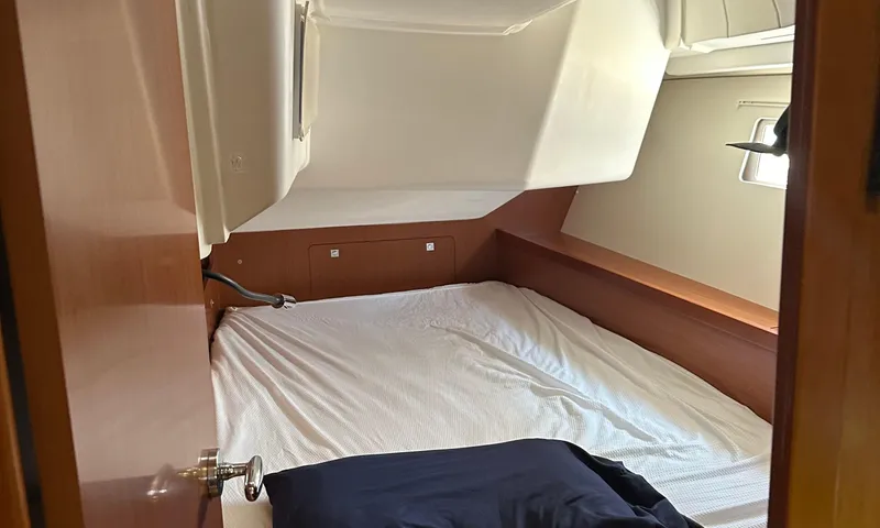 Lele Kalua Yacht Photos Pics Cozy cabin interior of 2014 Beneteau Oceanis 41 sailboat with bed and wooden finish.