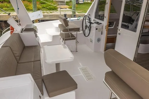 Honu Kai Yacht Photos Pics 2019 Seawind 1260 catamaran cockpit with seating, steering wheel, and tables.
