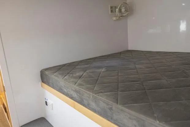 Honu Kai Yacht Photos Pics Interior cabin of 2019 Seawind 1260 catamaran with a comfortable bed and fan.