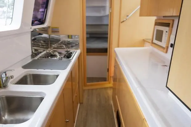 Honu Kai Yacht Photos Pics 2019 Seawind 1260 yacht interior kitchen with dual sinks and modern appliances.