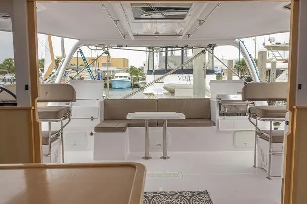 Honu Kai Yacht Photos Pics 2019 Seawind 1260 catamaran interior with seating and table, docked at marina.