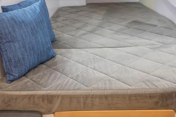 Honu Kai Yacht Photos Pics Cozy interior of 2019 Seawind 1260 with plush bedding and blue pillow.