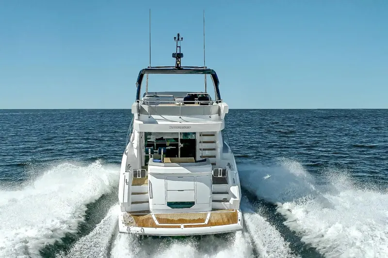  Yacht Photos Pics 2021 Sunseeker Manhattan 55 yacht cruising on open sea, rear view.