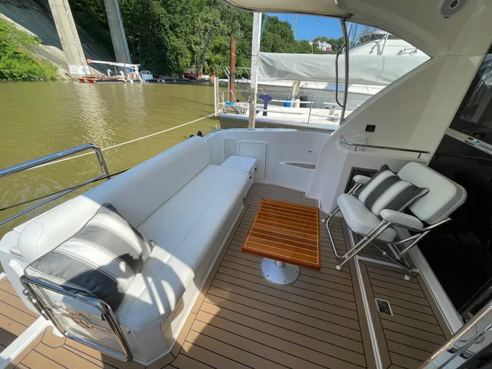 Esquire Yacht Photos Pics Luxurious 2017 Riviera 3600 Sport Yacht deck with elegant seating and wooden table.