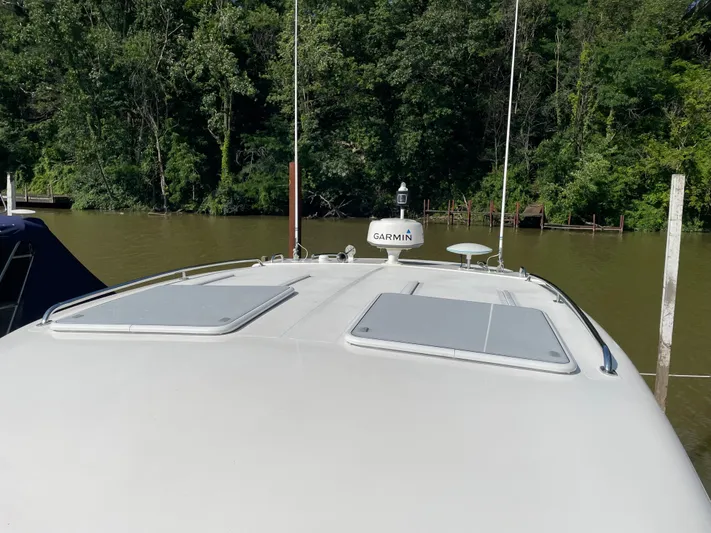 Esquire Yacht Photos Pics 2017 Riviera 3600 Sport Yacht with Garmin equipment, docked by a lush, wooded shoreline.