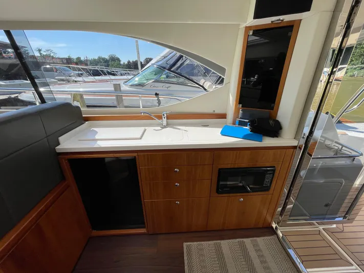 Esquire Yacht Photos Pics Interior of 2017 Riviera 3600 Sport Yacht with kitchenette and seating area.