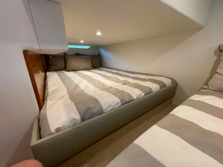 Esquire Yacht Photos Pics Cozy bedroom in 2017 Riviera 3600 Sport Yacht with striped bedding and soft lighting.