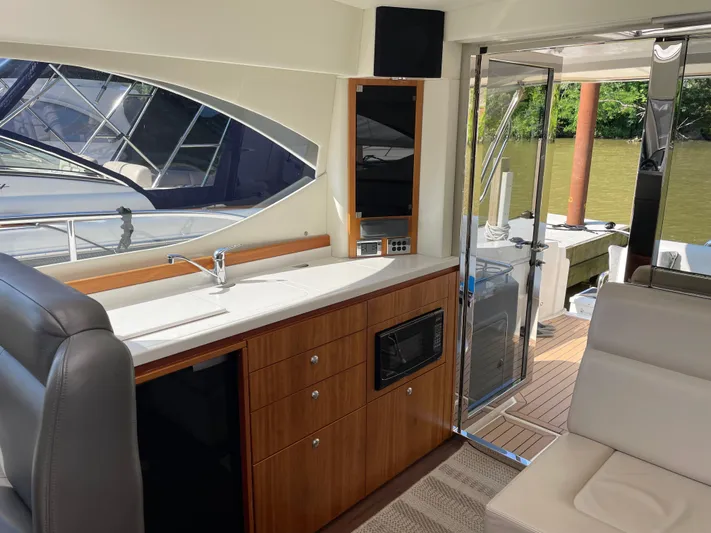 Esquire Yacht Photos Pics Interior of 2017 Riviera 3600 Sport Yacht with kitchenette and outdoor view.