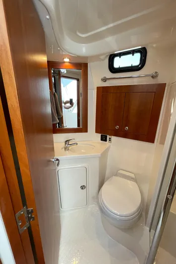 Esquire Yacht Photos Pics 2017 Riviera 3600 Sport Yacht bathroom with wooden cabinets and modern fixtures.