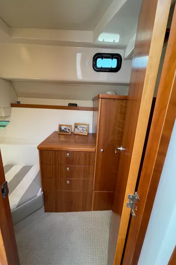 Esquire Yacht Photos Pics 2017 Riviera 3600 Sport Yacht cabin with wooden cabinetry and cozy bed.