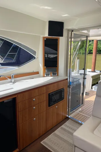Esquire Yacht Photos Pics Interior of 2017 Riviera 3600 Sport Yacht with kitchenette and outdoor view.