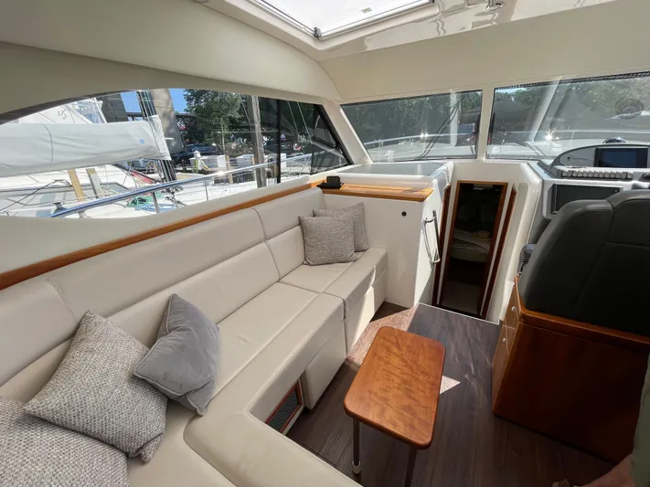 Esquire Yacht Photos Pics Interior of 2017 Riviera 3600 Sport Yacht with plush seating and wooden accents.