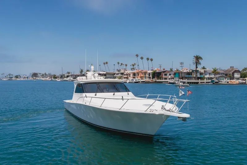 Endurance Yacht Photos Pics 2008 Viking 52 Sport Coupe yacht cruising near coastal homes under clear blue skies.