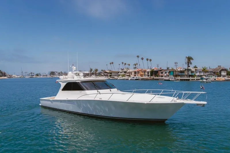 Endurance Yacht Photos Pics 2008 Viking 52 Sport Coupe yacht cruising near coastal homes under clear blue skies.