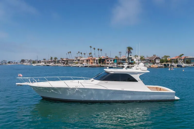 Endurance Yacht Photos Pics 2008 Viking 52 Sport Coupe yacht cruising near coastal homes under clear blue skies.