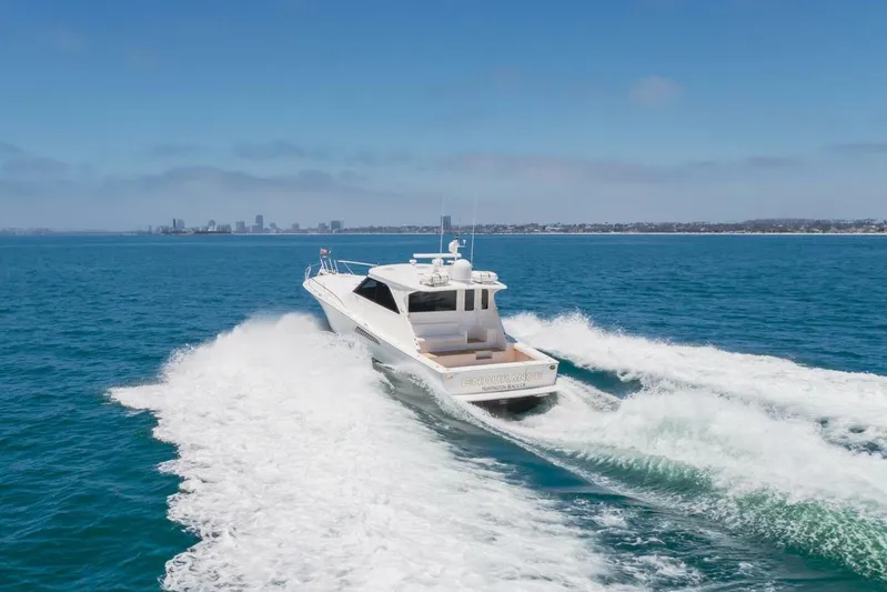 Endurance Yacht Photos Pics 2008 Viking 52 Sport Coupe cruising on open water, city skyline in background.