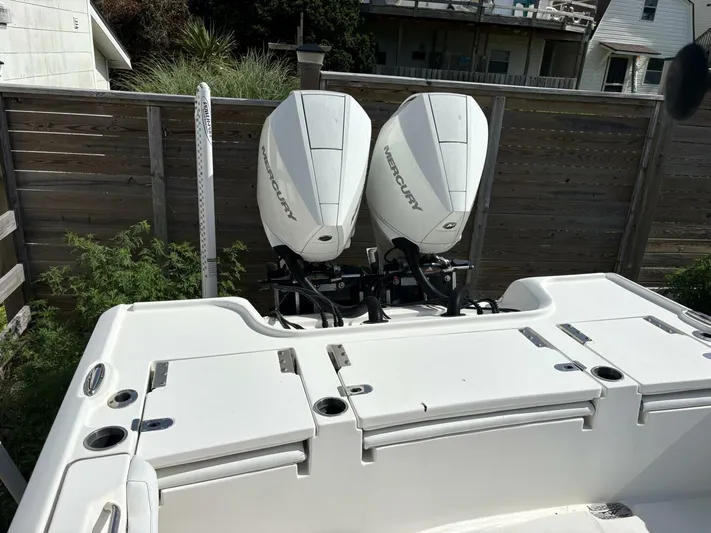  Yacht Photos Pics 2019 Tidewater 2700 Carolina Bay boat with dual Mercury engines, docked near wooden fence.