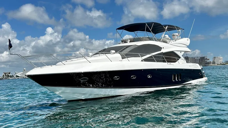 2006 Sunseeker Manhattan 60 @ Cancun Yacht Photos Pics 2006 Sunseeker Manhattan 60 yacht cruising on clear blue water under a partly cloudy sky.