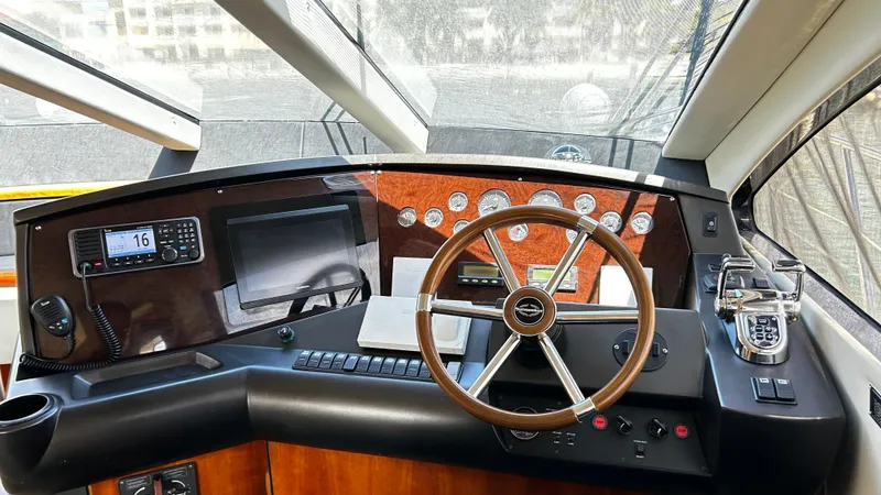 2006 Sunseeker Manhattan 60 @ Cancun Yacht Photos Pics Helm of 2006 Sunseeker Manhattan 60 yacht with steering wheel and navigation controls.