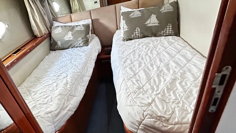 2006 Sunseeker Manhattan 60 @ Cancun Yacht Photos Pics Twin cabin interior of 2006 Sunseeker Manhattan 60 yacht with nautical-themed pillows.