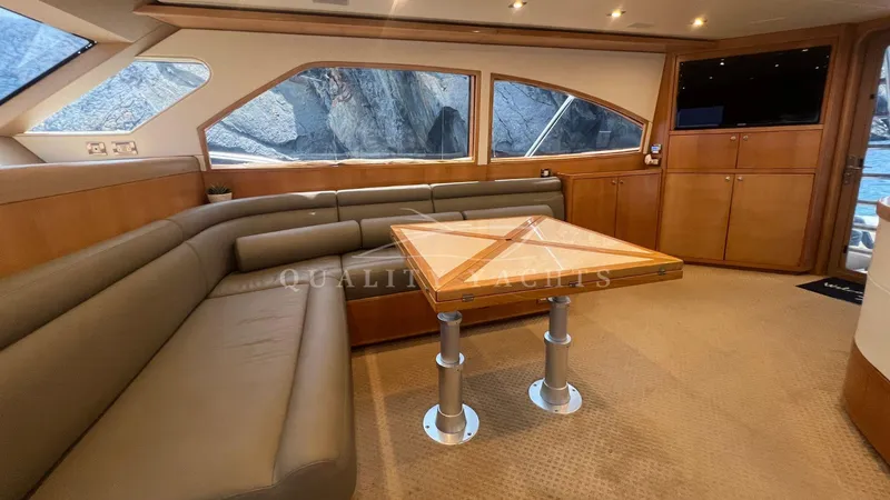 Saietta Yacht Photos Pics Interior of a 2010 Bertram Convertible yacht with leather seating and wooden table.