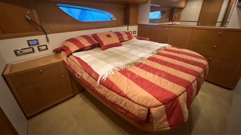 Saietta Yacht Photos Pics Luxurious bedroom interior of a 2010 Bertram Convertible yacht with striped bedding.