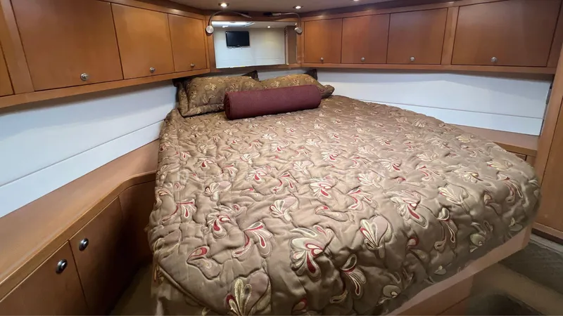 Saietta Yacht Photos Pics Luxurious bedroom in a 2010 Bertram Convertible yacht with elegant bedding and ample storage.