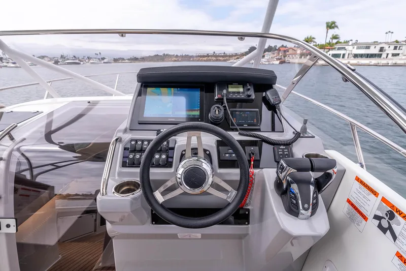  Yacht Photos Pics 2023 Jeanneau Leader 9.0 WA helm with advanced navigation controls and scenic marina view.