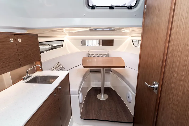  Yacht Photos Pics 2023 Jeanneau Leader 9.0 WA cabin interior with seating and kitchenette.