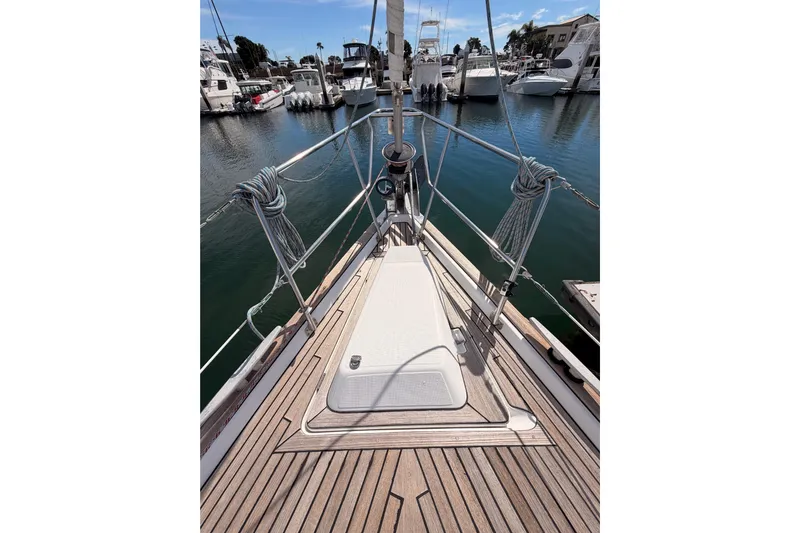 Tadpole Yacht Photos Pics 2005 Beneteau Oceanis Clipper 423 sailboat deck in marina, showcasing teak wood finish.