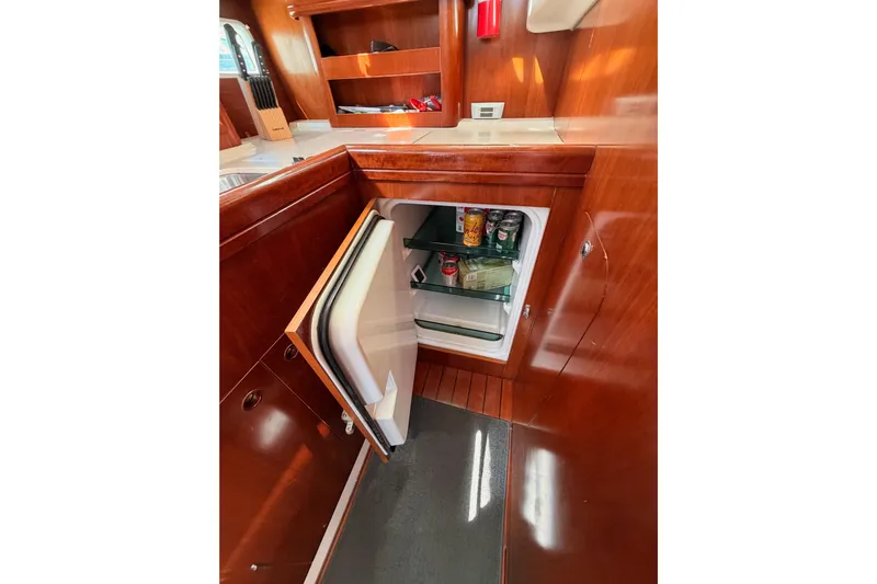 Tadpole Yacht Photos Pics Interior of 2005 Beneteau Oceanis Clipper 423 yacht with open fridge in wooden cabinetry.