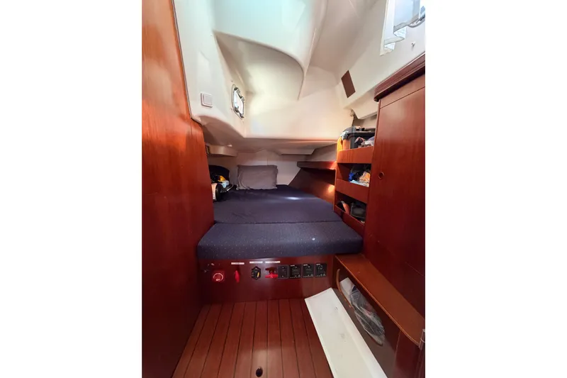Tadpole Yacht Photos Pics Interior cabin of 2005 Beneteau Oceanis Clipper 423 with wooden finish and cozy bedding.