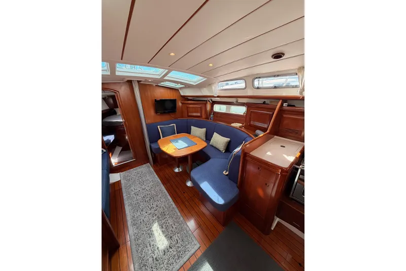 Tadpole Yacht Photos Pics Luxurious interior of 2005 Beneteau Oceanis Clipper 423 yacht with blue seating and wooden finishes.