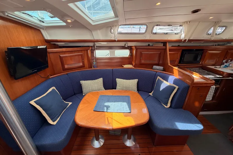Tadpole Yacht Photos Pics Luxurious interior of 2005 Beneteau Oceanis Clipper 423 yacht with cozy seating and elegant wood finish.