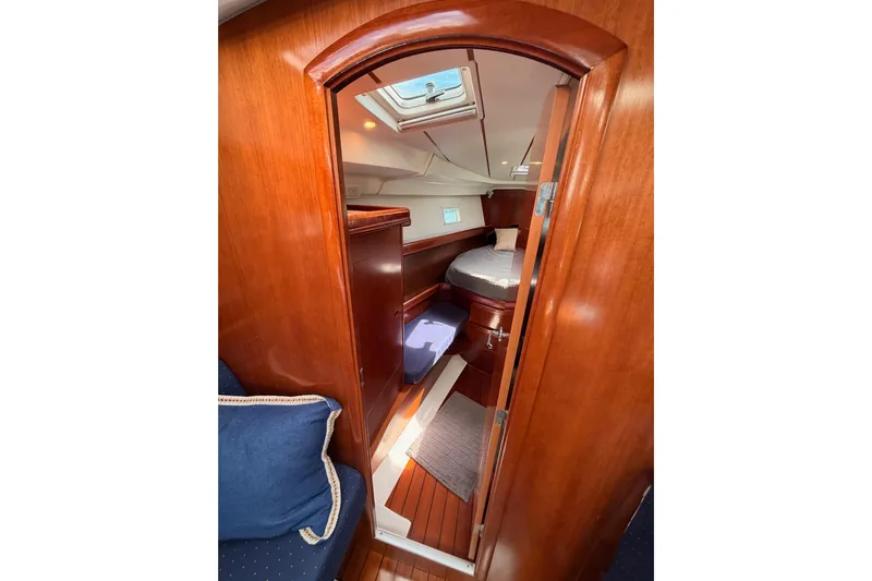 Tadpole Yacht Photos Pics Interior of 2005 Beneteau Oceanis Clipper 423 yacht cabin with wooden finish and cozy bedding.