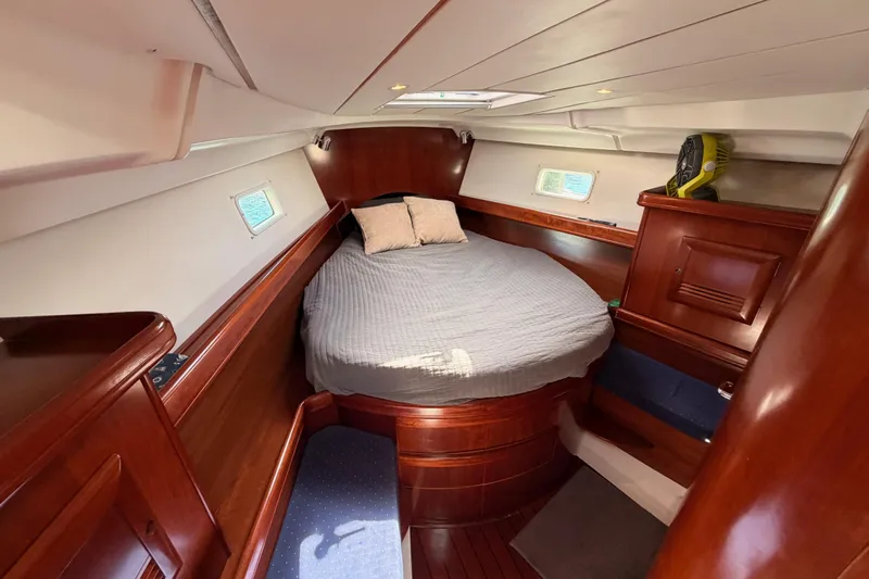 Tadpole Yacht Photos Pics Cozy cabin interior of 2005 Beneteau Oceanis Clipper 423 with wooden finish and comfortable bedding.