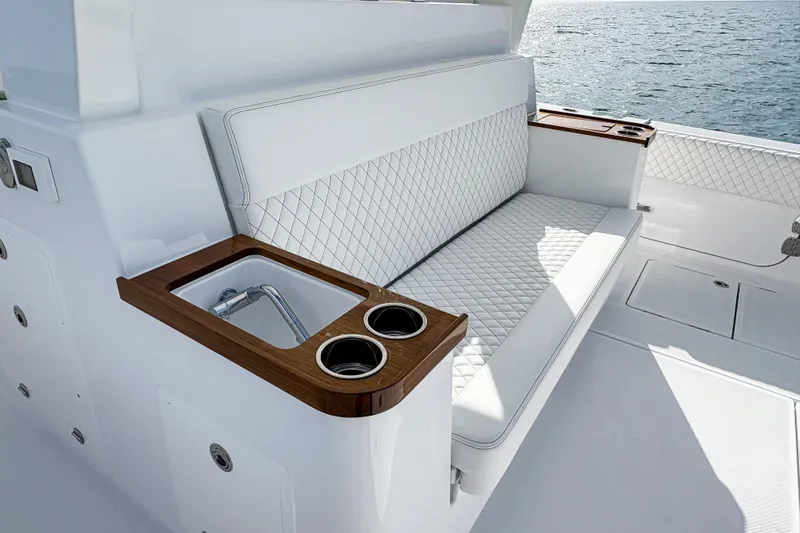  Yacht Photos Pics Luxurious seating area on 2026 HCB 48 Campeon boat with sink and cup holders.