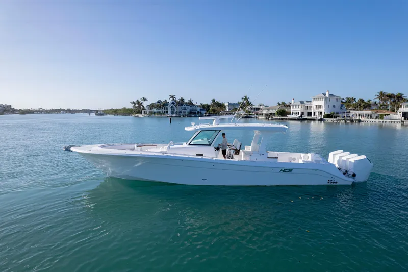  Yacht Photos Pics 2026 HCB 48 Campeon boat cruising on a sunny day near waterfront homes.